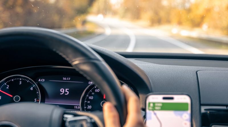 Șofer la volan folosind navigația GPS în timpul deplasării pe un drum.
